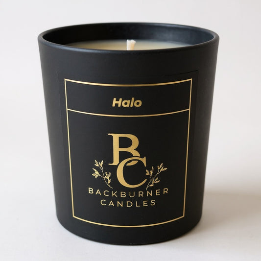 Unlit Halo vegan candle by Backburner Candles in black jar with gold logo and floral design, styled for a premium, elegant look.