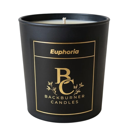 Unlit Euphoria vegan candle by Backburner Candles in black jar with gold logo and floral design, styled for a premium, elegant look.