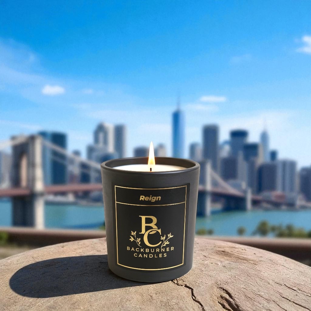 Reign candle by Backburner Candles in a black container on a stone ledge with a cityscape background
