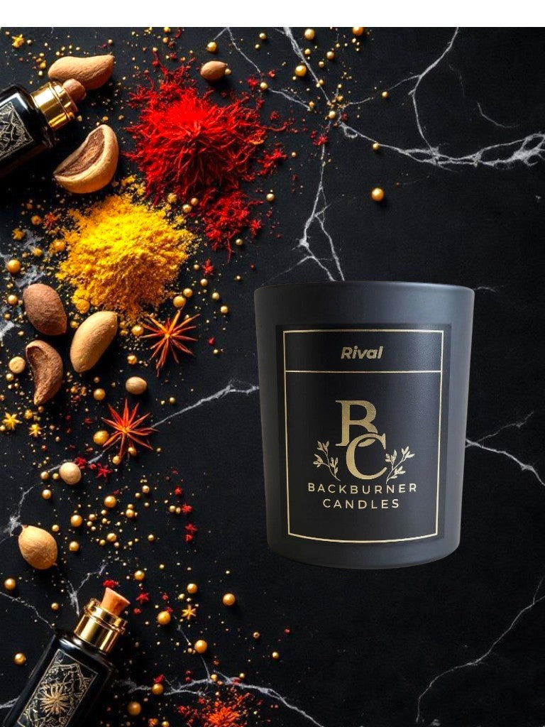 Backburner Candles Rival candle on a dark surface with spices and oils.