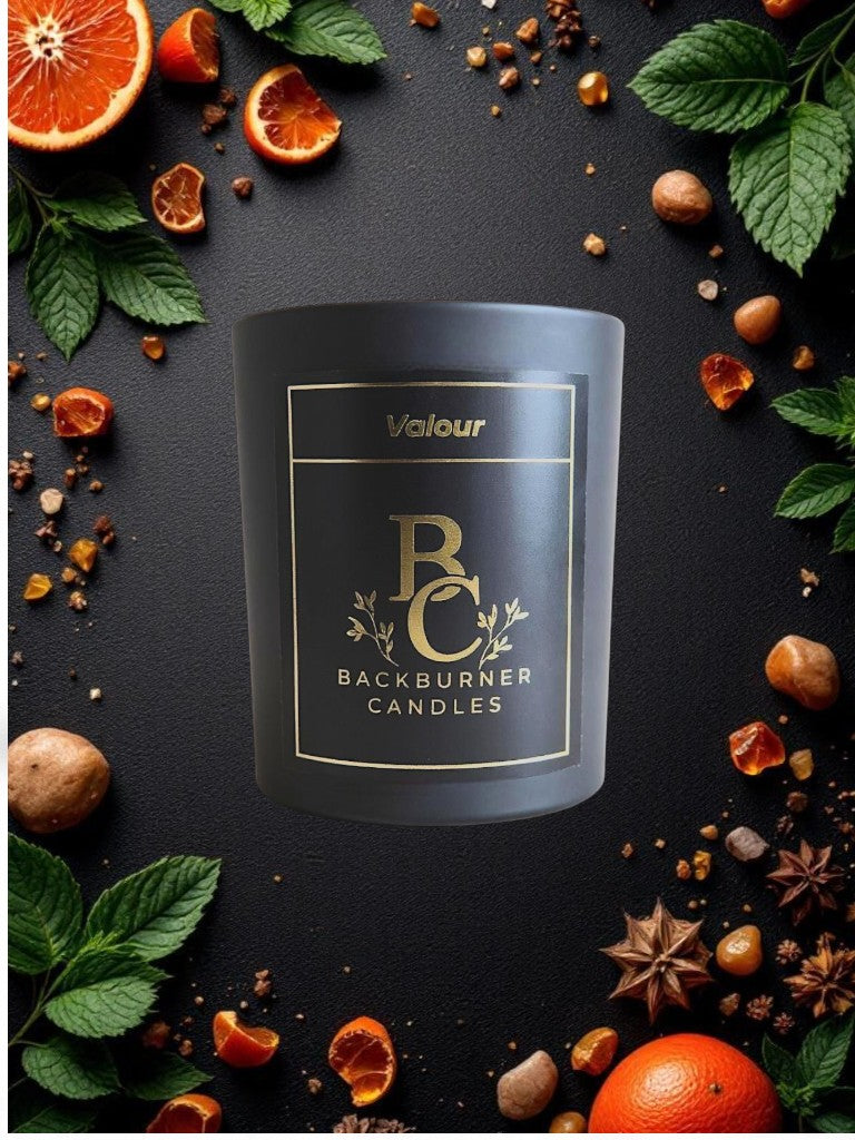 Valour vegan candle by Backburner Candles in black jar, styled with dried fruits, spices & herbs for a natural, luxurious presentation.