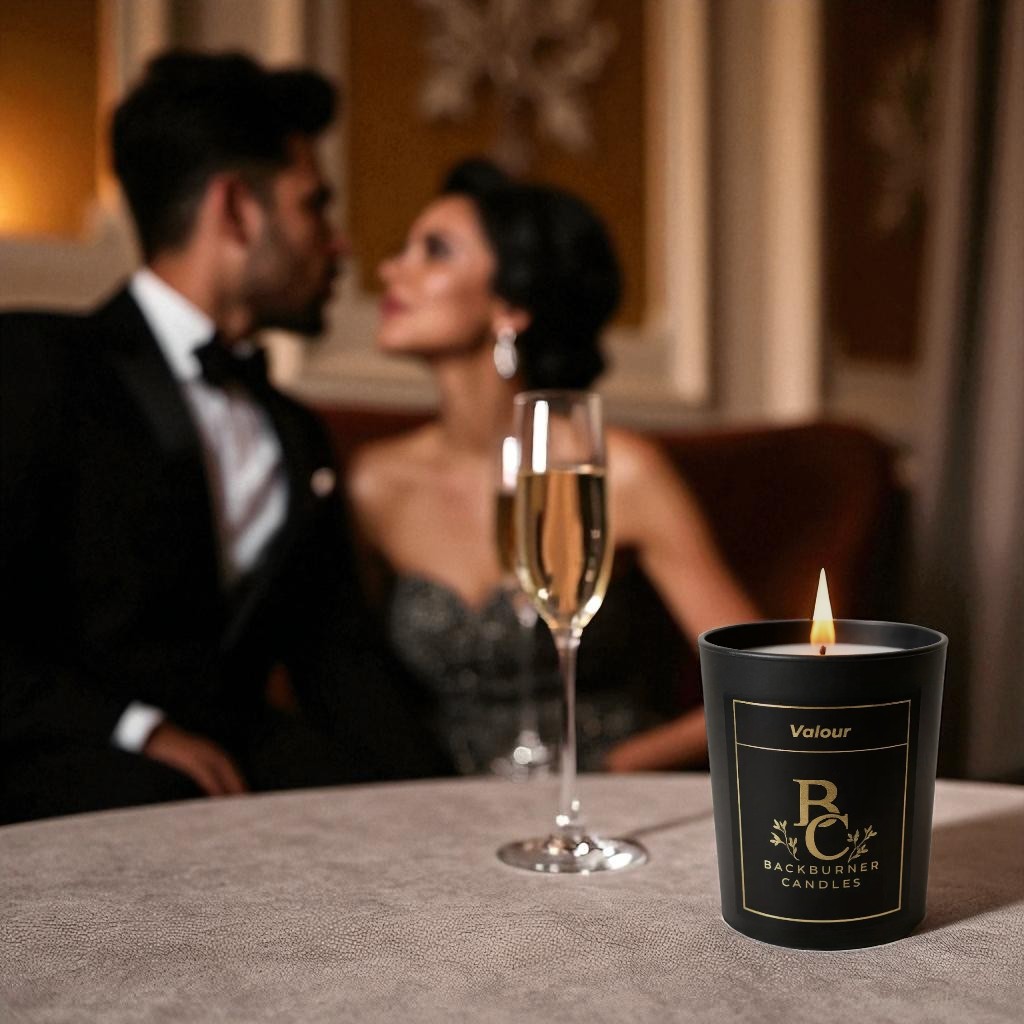 Lit Valour vegan candle by Backburner Candles on elegant table with champagne, styled for romantic luxury with a formally dressed couple.