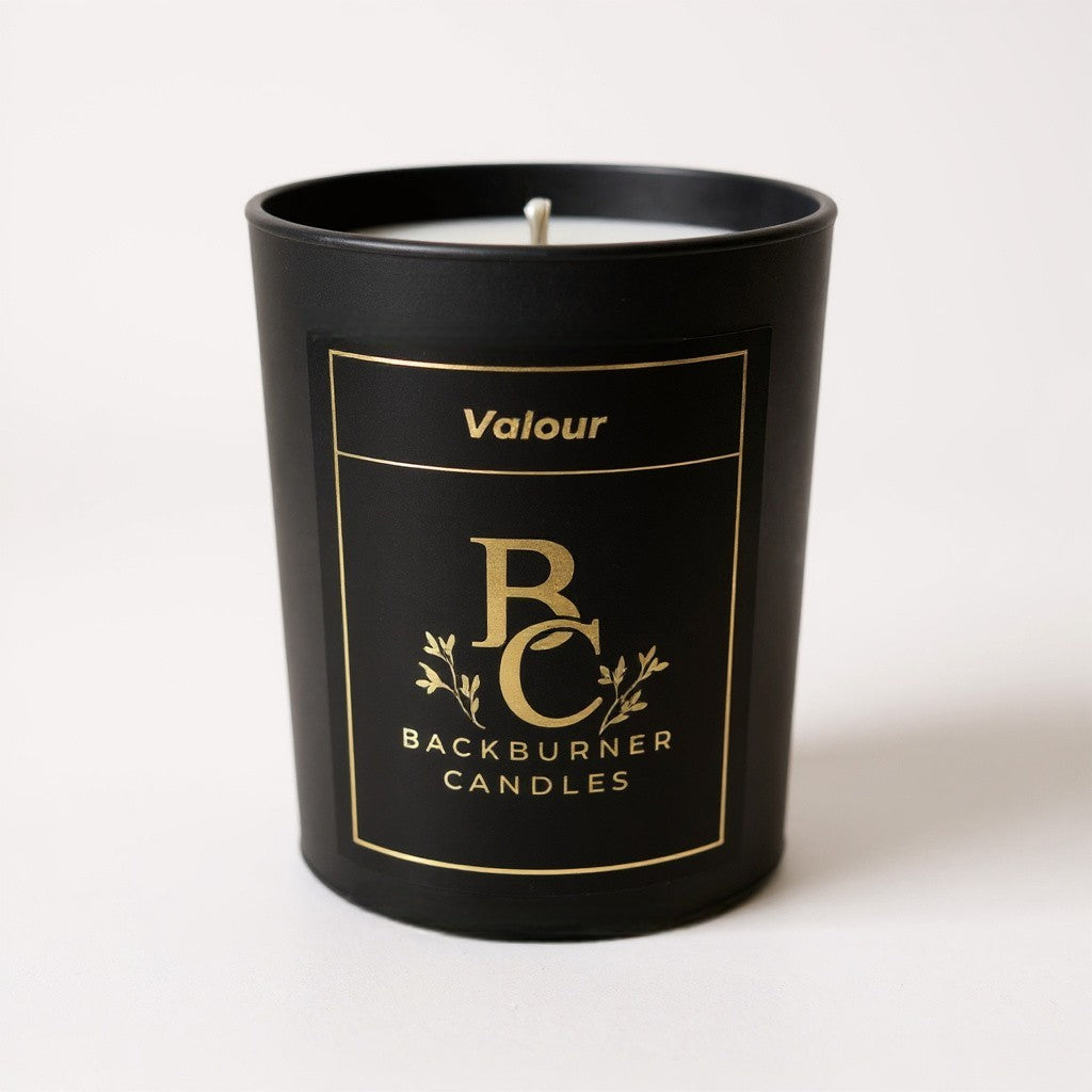 Unlit Valour vegan candle by Backburner Candles in black jar with gold logo and floral design, styled for a premium, elegant look.