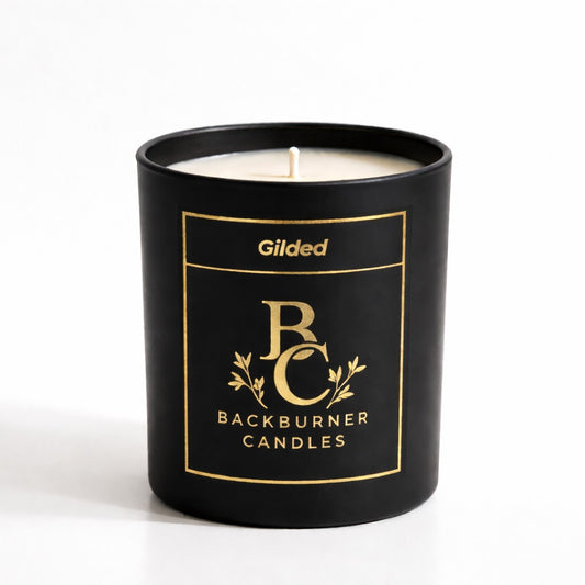 Black candle in a container with 'Backburner Candles' branding on a white background