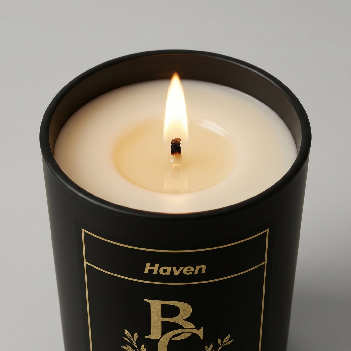 Candle in a black container labeled 'Haven' on a gray background