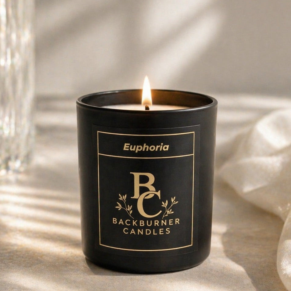Black candle with 'Backburner Candles' label on a light surface