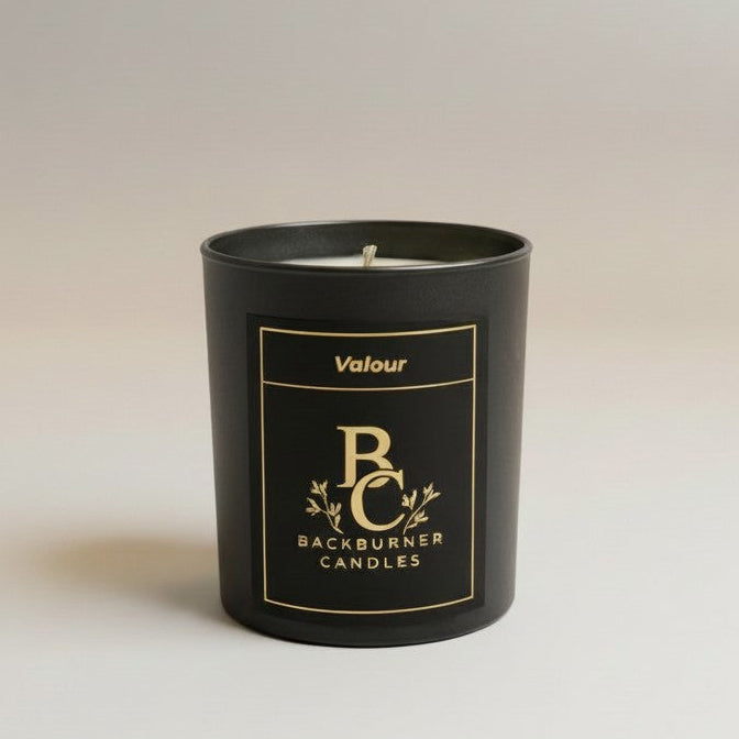 Unlit Valour vegan candle by Backburner Candles in black jar with gold logo and floral design, styled for a premium, elegant look.
