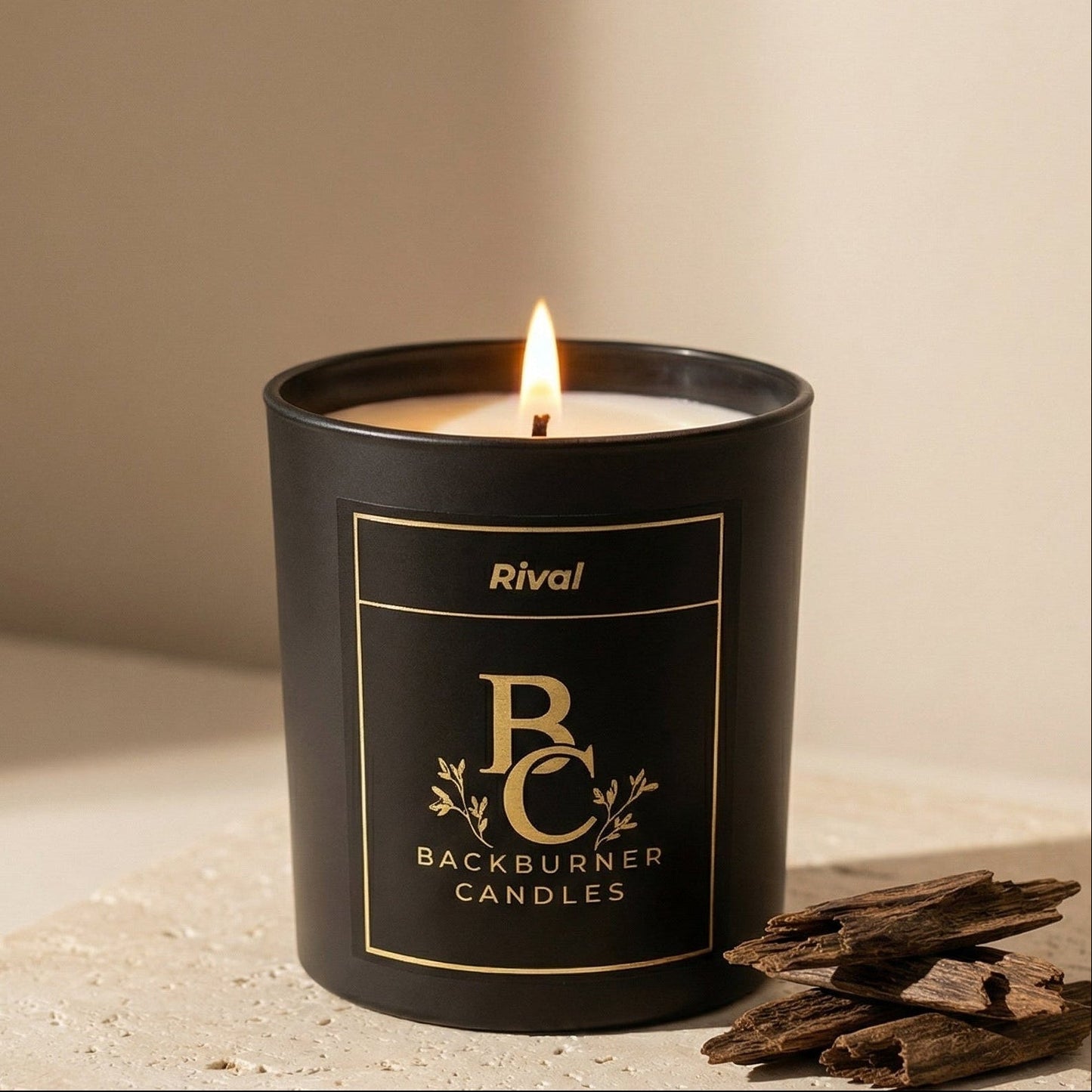 Black candle with 'Backburner Candles' label on a light surface