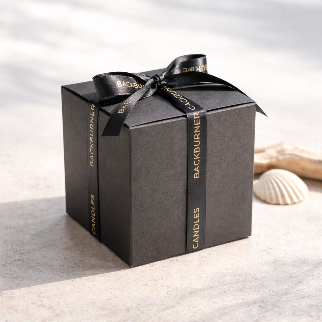 Black gift box with 'Backburner Candles' ribbon on a light background